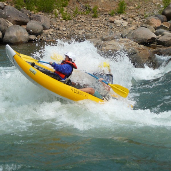 a man riding a surfboard on a raft in a body of water