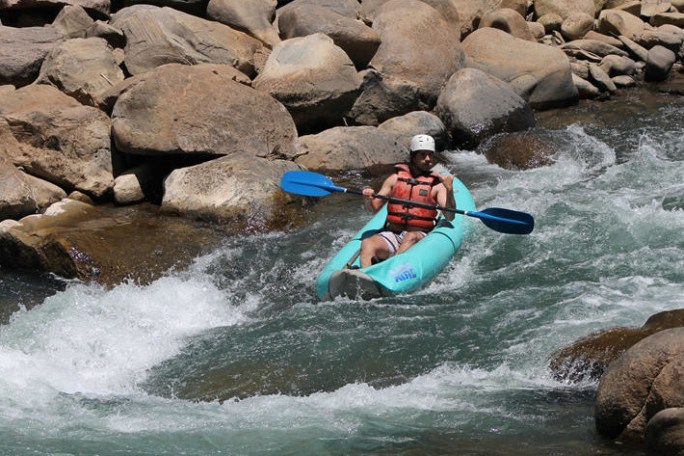 a man riding a wave on top of a rock