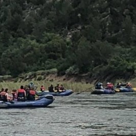 a group of people rowing a boat in a body of water