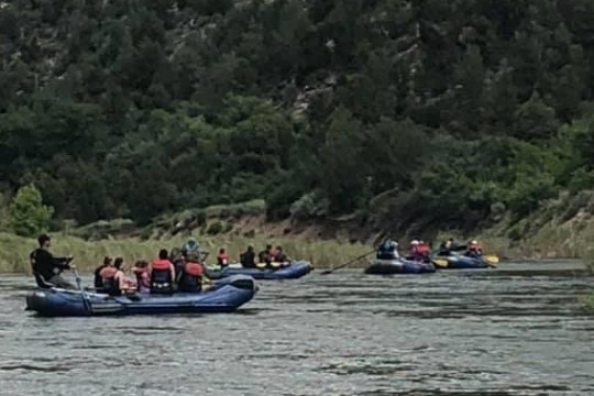 a group of people rowing a boat in a body of water