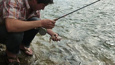 a man standing next to a body of water