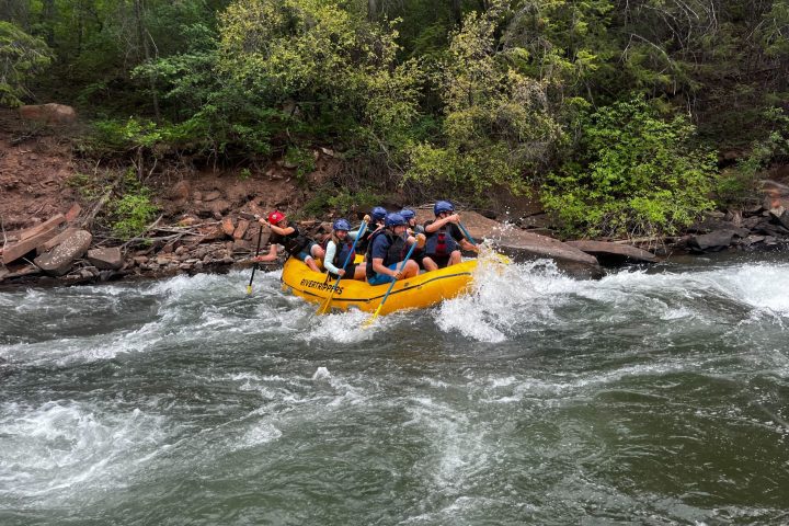 a group of people riding on a raft in a body of water
